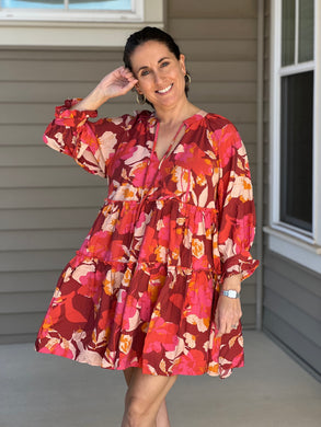 pinks, reds, and orange florals are artfully combined in a flowy, 3/4 sleeve tiered mini dress. 