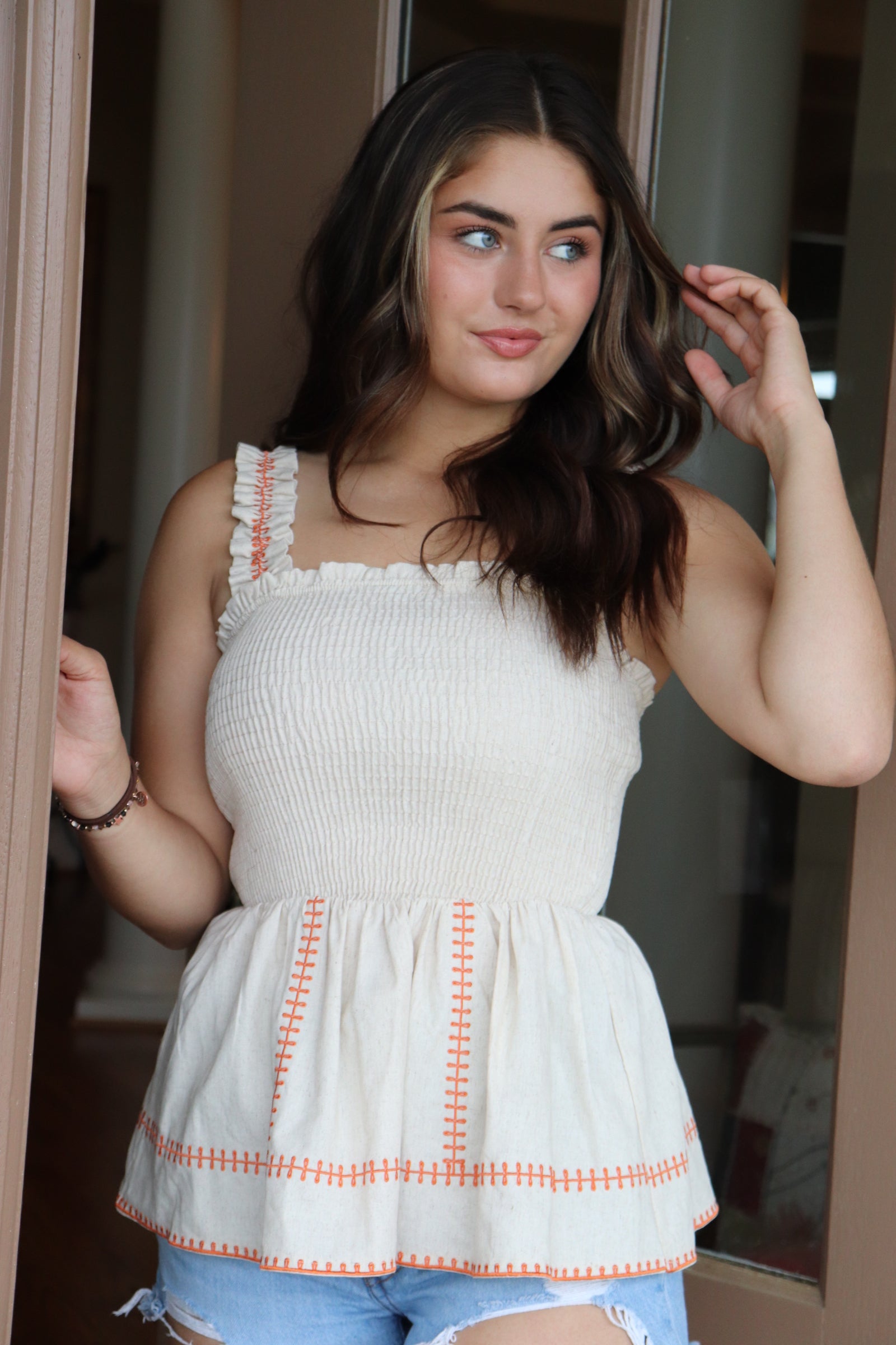 smocked linen peplum top with orange stitching