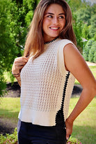 Cream sleeveless loose knit sweater with black stitching down the sides