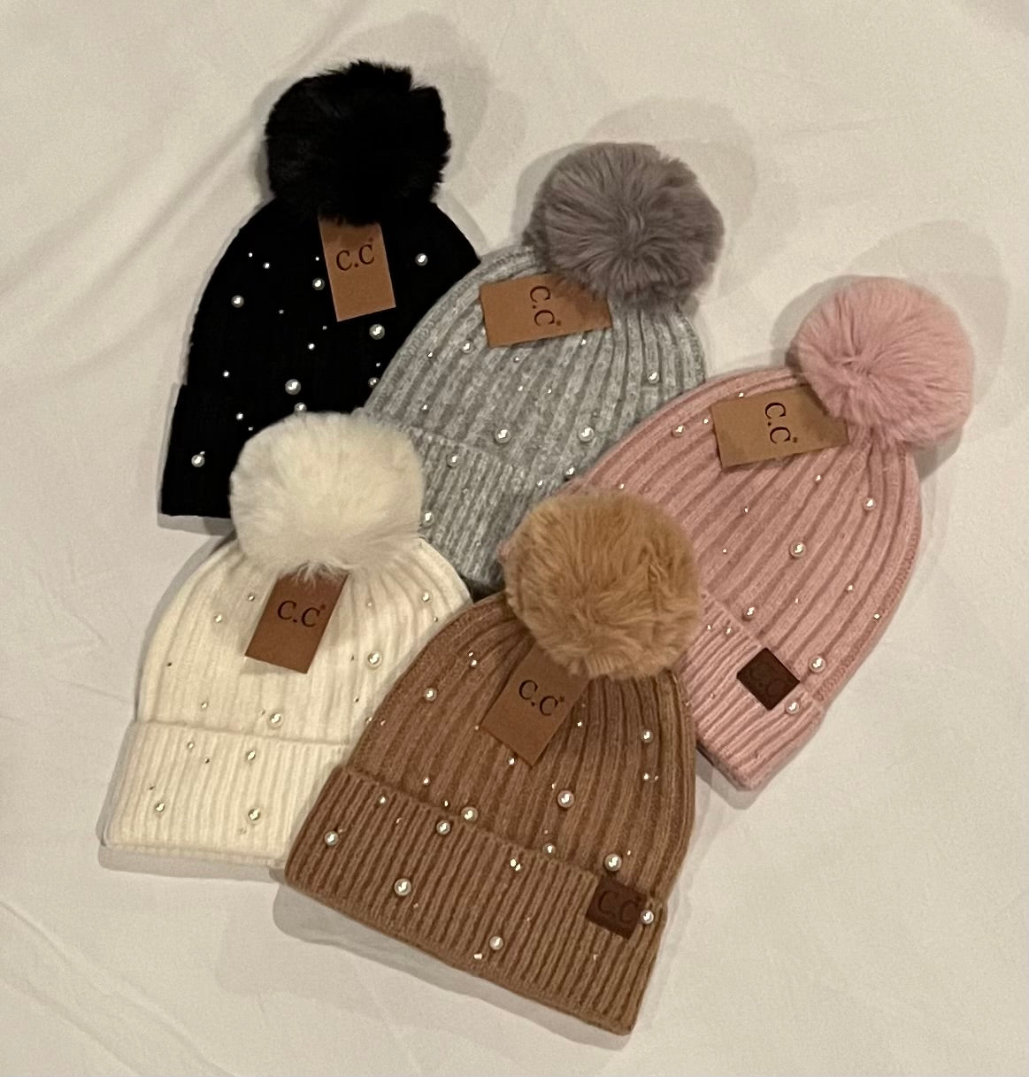 Pom beanie adorned with pearl embellishments. Five colors. Black, gray, mauve, ivory, camel