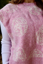 Pink short sleeve sweater vest with while floral print design