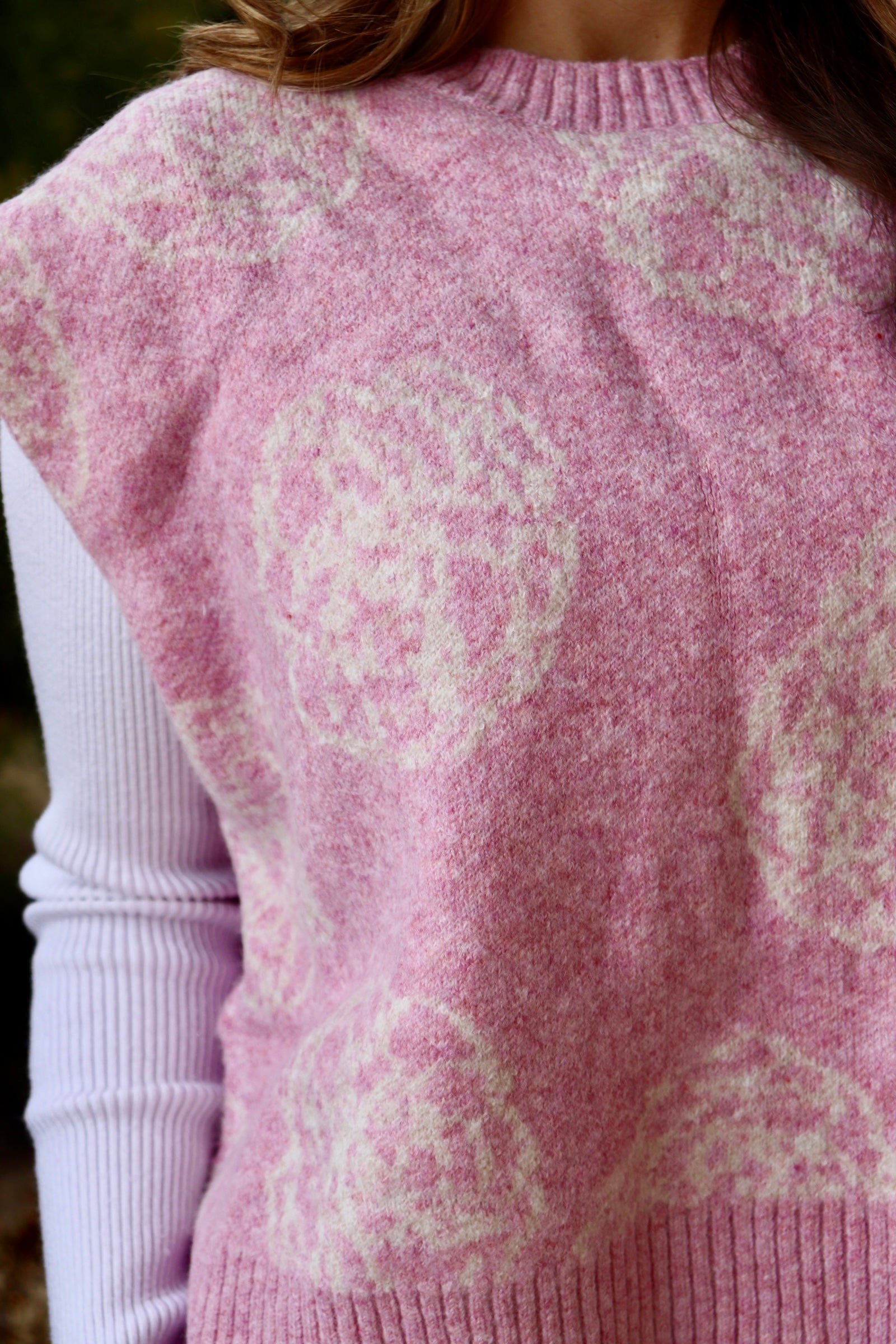 Pink short sleeve sweater vest with while floral print design